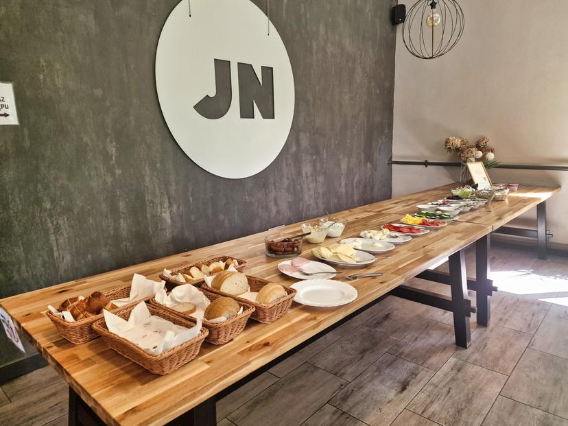 Bufet śniadaniowy z chlebem, wędlinami i serami w jadalni ośrodka