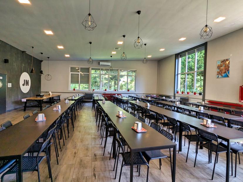 Przestronna, nowoczesna sala jadalna ze stołami i krzesłami dla uczestników