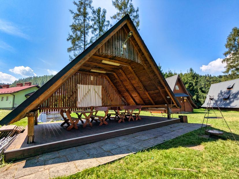 Przestronne drewniane altany z dachem i stołami piknikowymi na świeżym powietrzu